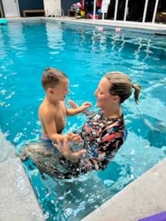 woman teach boy swimming